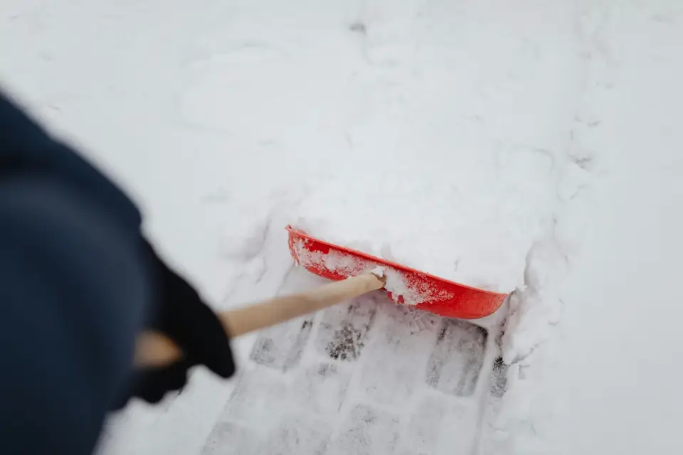A red snow shovel clearing fresh snow