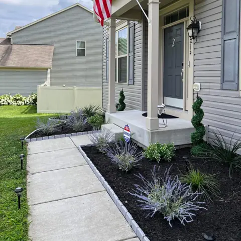 Front walkway lined with a fresh mulch bed and low plants